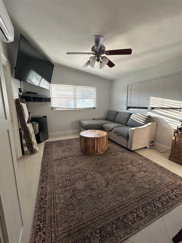 living room with an AC wall unit, light tile patterned floors, and ceiling fan