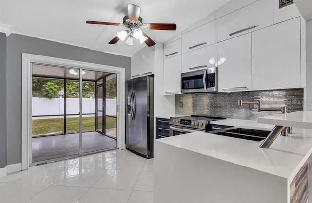 kitchen with sink, white cabinetry, tasteful backsplash, kitchen peninsula, and stainless steel appliances