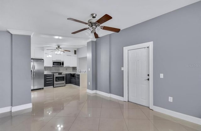 kitchen with light tile patterned floors, ceiling fan, appliances with stainless steel finishes, white cabinets, and decorative backsplash