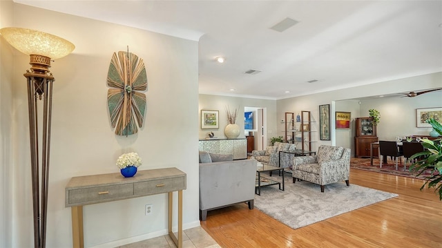 living room featuring ornamental molding and light hardwood / wood-style flooring