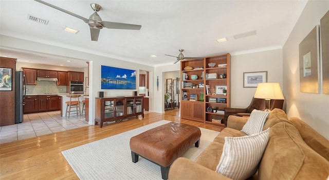 living room with light wood-type flooring and ceiling fan