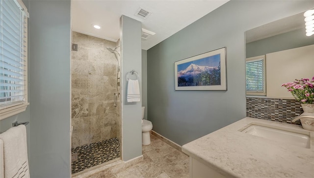 bathroom with walk in shower, vanity, and toilet