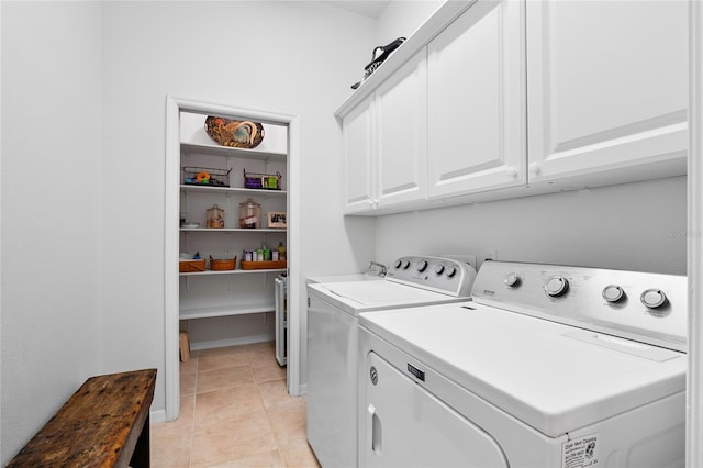 laundry area featuring light tile patterned flooring, cabinets, and washer and dryer