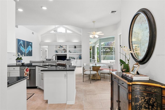 kitchen with lofted ceiling, sink, ceiling fan, white cabinets, and stainless steel dishwasher