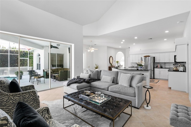 tiled living room with high vaulted ceiling and ceiling fan