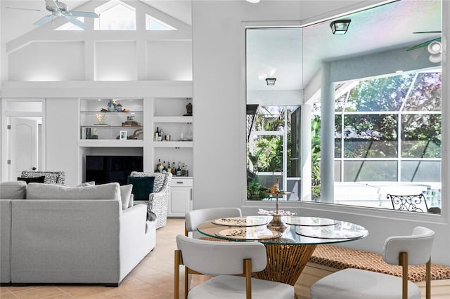 tiled living room with ceiling fan, plenty of natural light, high vaulted ceiling, and built in features