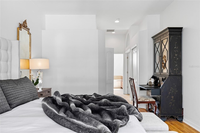 bedroom featuring connected bathroom and light wood-type flooring