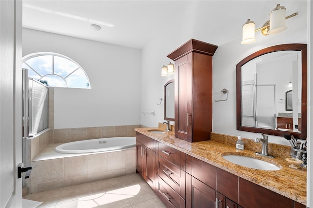 bathroom featuring vanity, tile patterned floors, and tiled bath