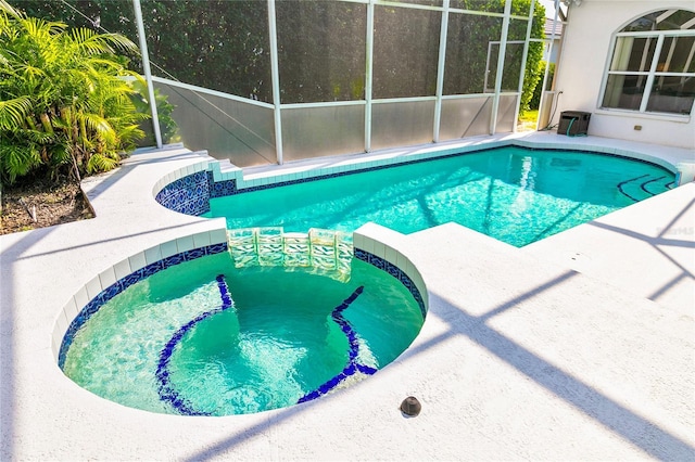 view of pool featuring glass enclosure and an in ground hot tub