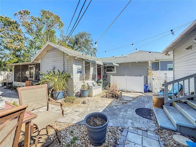 back of property with a sunroom and a patio