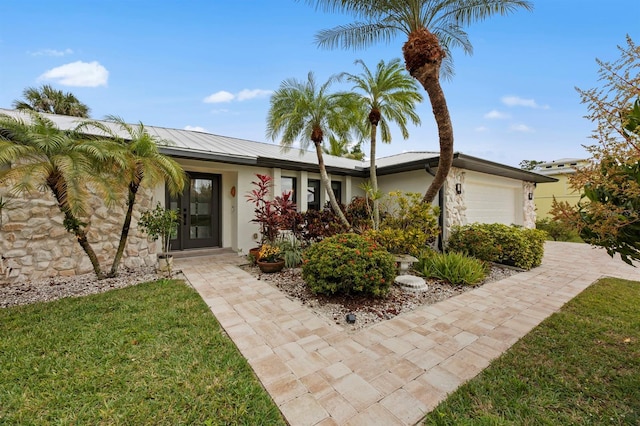 ranch-style home featuring a garage and a front lawn