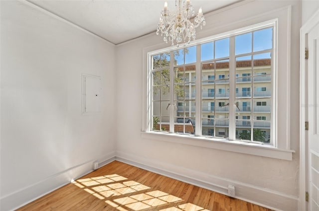 unfurnished dining area with light wood finished floors, baseboards, and an inviting chandelier