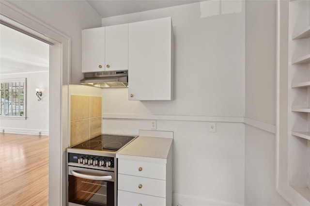 kitchen with light countertops, white cabinets, electric stove, under cabinet range hood, and light wood-type flooring