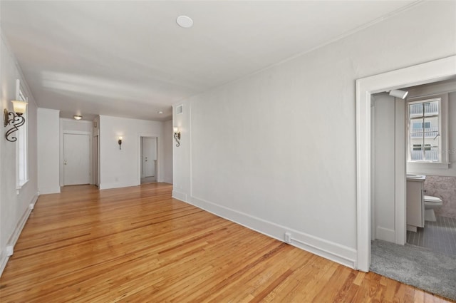 unfurnished room featuring baseboards and light wood finished floors