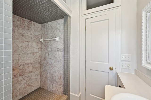 bathroom featuring a tile shower and vanity