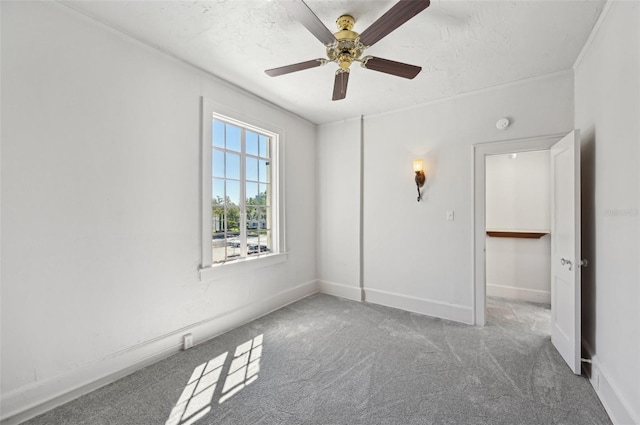 unfurnished bedroom with a textured ceiling, carpet flooring, baseboards, and ceiling fan