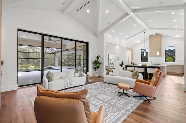 living room featuring hardwood / wood-style floors, beam ceiling, and high vaulted ceiling