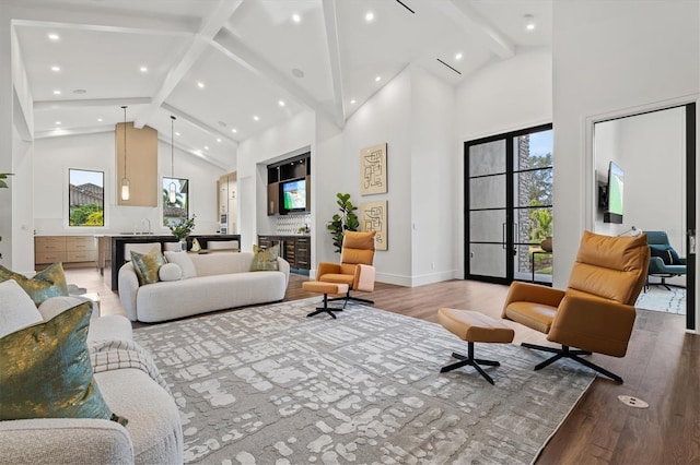 living room featuring hardwood / wood-style flooring, sink, high vaulted ceiling, and beamed ceiling