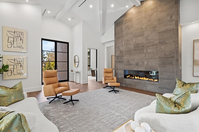 living room with a tile fireplace, high vaulted ceiling, wood-type flooring, and beam ceiling