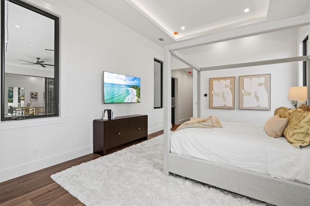 bedroom featuring dark hardwood / wood-style flooring and a raised ceiling