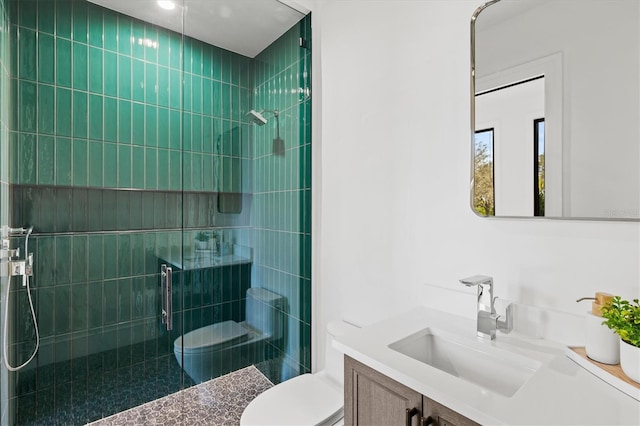 bathroom with vanity, toilet, and a tile shower