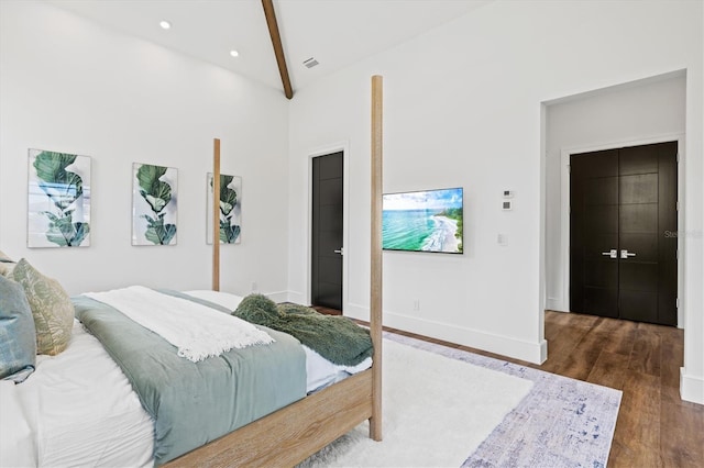 bedroom with dark hardwood / wood-style flooring and lofted ceiling with beams