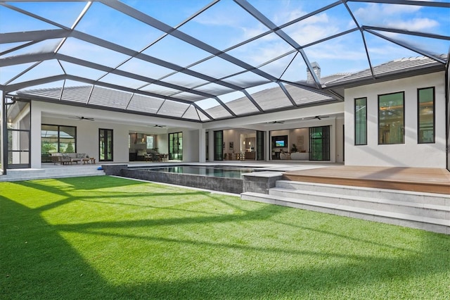 back of property featuring a patio, a yard, ceiling fan, and glass enclosure