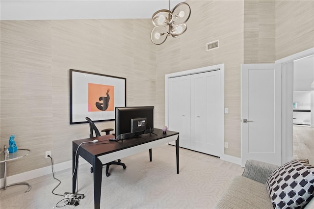 office area featuring a notable chandelier and a high ceiling