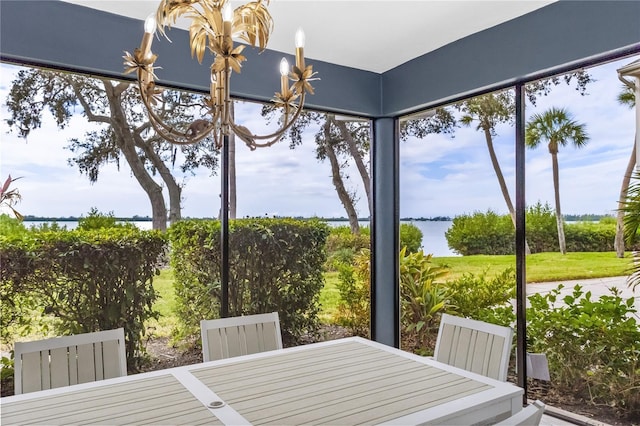 sunroom featuring a chandelier and a water view