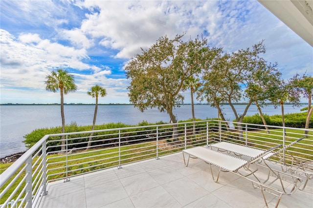 view of patio with a balcony and a water view