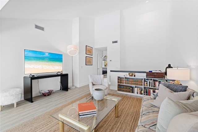 living room featuring hardwood / wood-style flooring and high vaulted ceiling