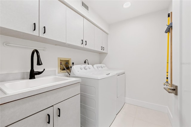 laundry area with cabinets, separate washer and dryer, sink, and light tile patterned floors