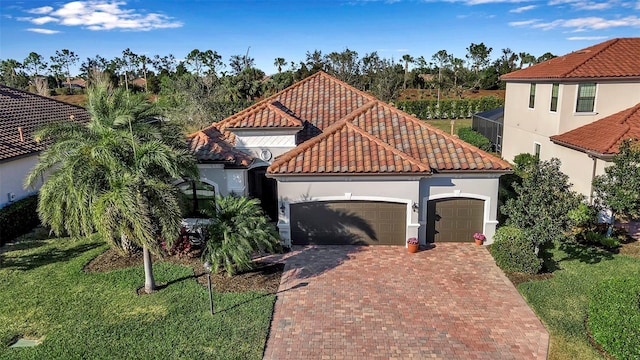 mediterranean / spanish home featuring a garage and a front yard