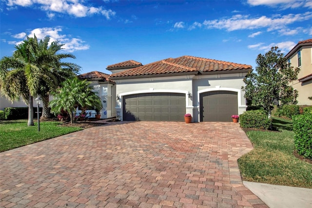 mediterranean / spanish-style home with a garage and a front lawn