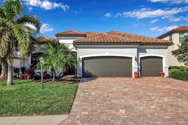 mediterranean / spanish home featuring a garage and a front yard