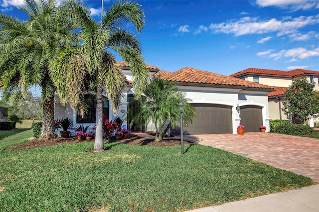 mediterranean / spanish-style house featuring a garage and a front lawn