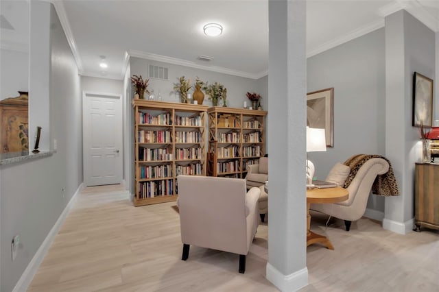 sitting room with ornamental molding and light hardwood / wood-style floors