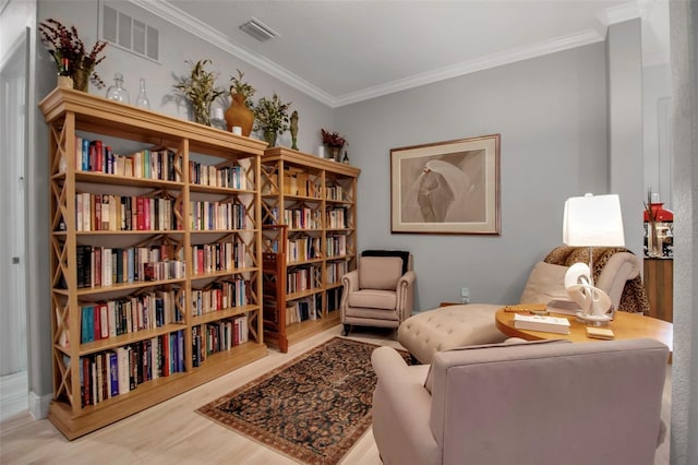 sitting room featuring ornamental molding and hardwood / wood-style floors