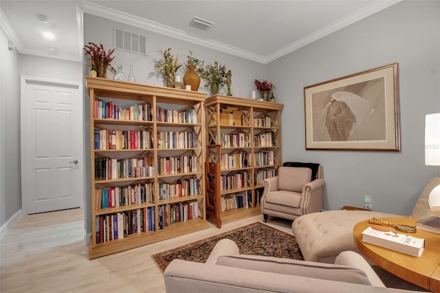 sitting room with crown molding and light hardwood / wood-style floors