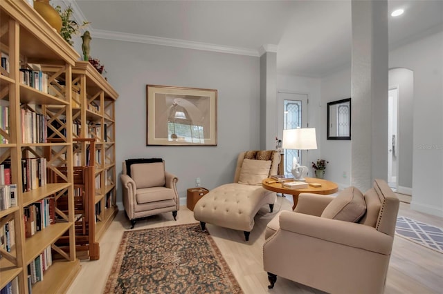 sitting room with crown molding and light hardwood / wood-style floors