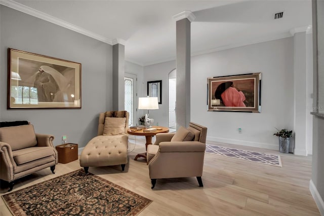 sitting room with crown molding and light wood-type flooring