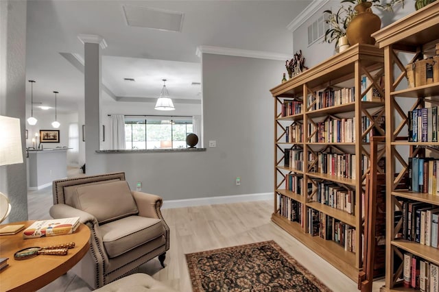 sitting room featuring crown molding and light hardwood / wood-style flooring