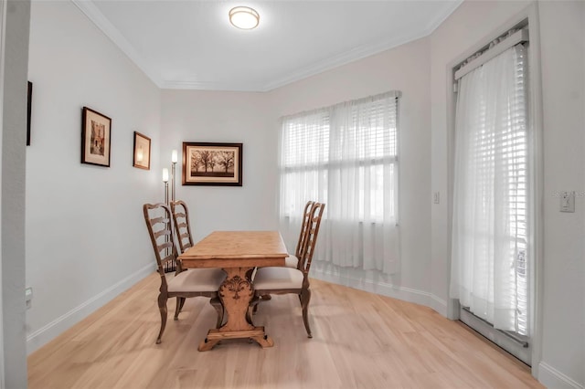 dining room with ornamental molding and light wood-type flooring