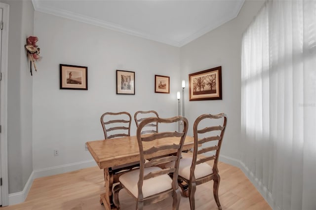 dining room with crown molding and light hardwood / wood-style floors