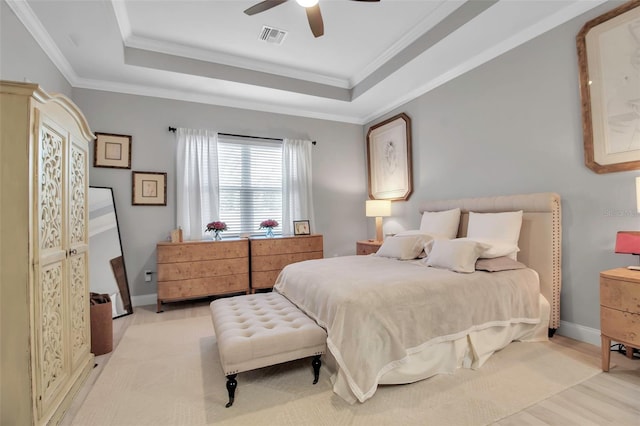 bedroom featuring a raised ceiling, crown molding, and ceiling fan