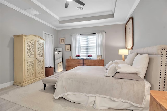 bedroom with ceiling fan, ornamental molding, and a raised ceiling