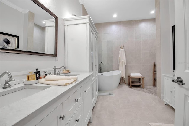 bathroom featuring tile patterned floors, vanity, a bathtub, and tile walls