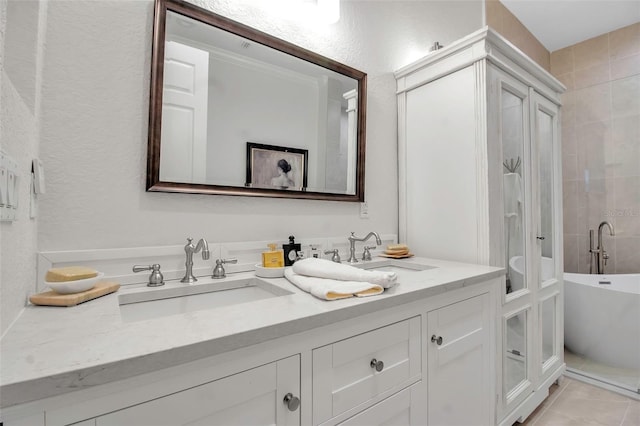 bathroom featuring vanity, tile patterned floors, and a tub to relax in