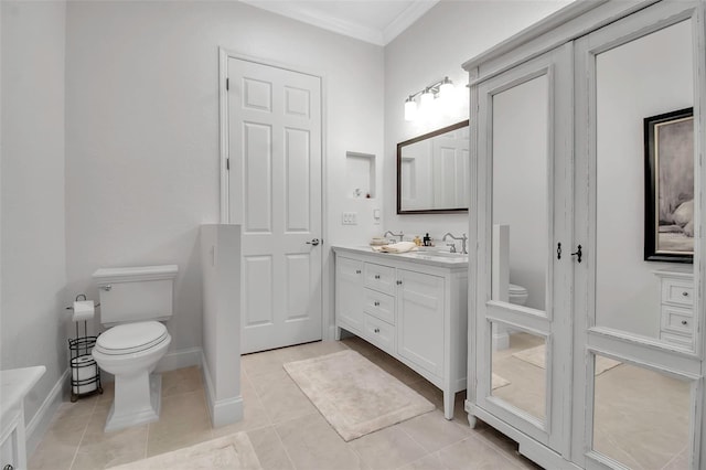 bathroom with tile patterned flooring, vanity, ornamental molding, and toilet