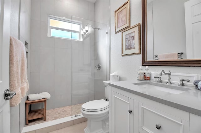 bathroom featuring tiled shower, vanity, and toilet